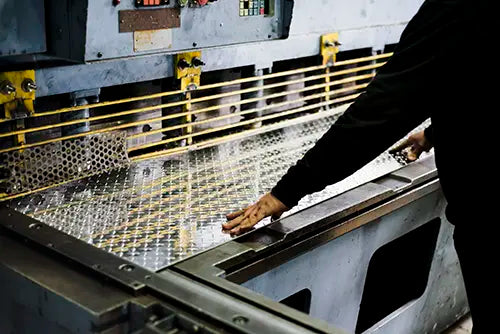 Opérateur utilisant une plieuse industrielle pour le façonnage de plaques d'acier sur mesure au Centre RP.