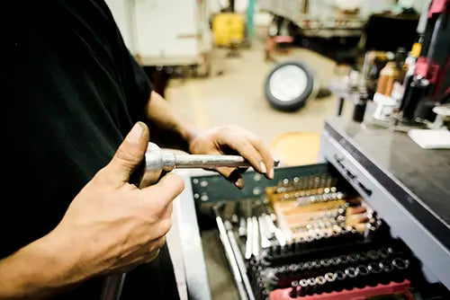 Technicien du Centre RP effectuant une réparation mécanique de précision sur une remorque